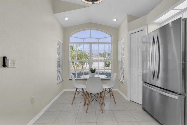 dining room featuring lofted ceiling, light tile patterned flooring, and baseboards