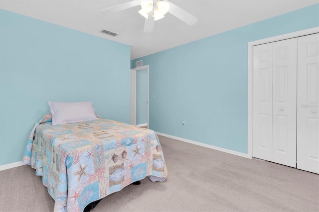 carpeted bedroom with a closet, visible vents, ceiling fan, and baseboards