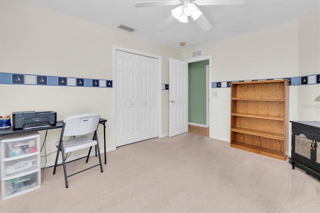 carpeted office with visible vents, ceiling fan, and baseboards