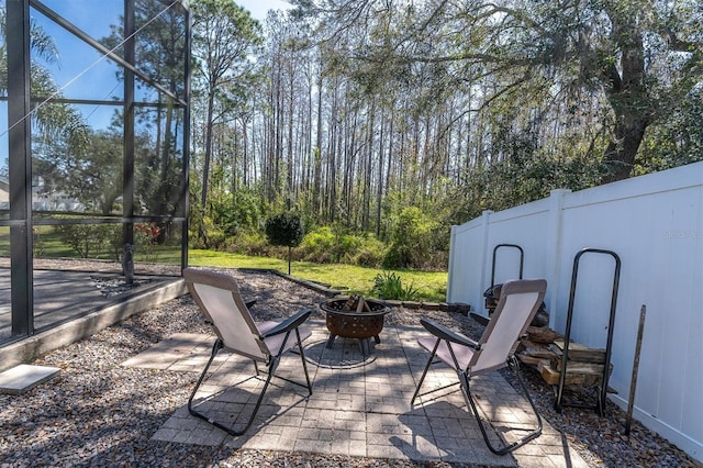 view of patio with a lanai and a fire pit