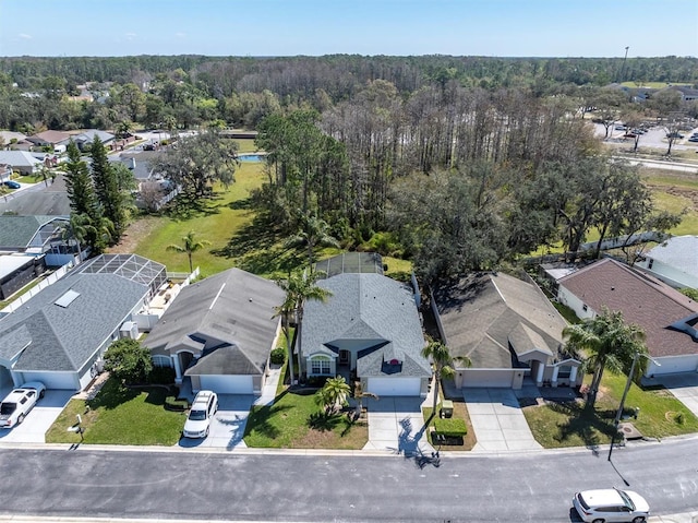 birds eye view of property featuring a wooded view and a residential view