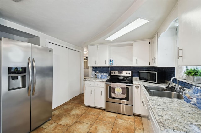 kitchen with appliances with stainless steel finishes, a sink, and white cabinetry