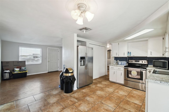 kitchen featuring stainless steel appliances, visible vents, white cabinets, and backsplash