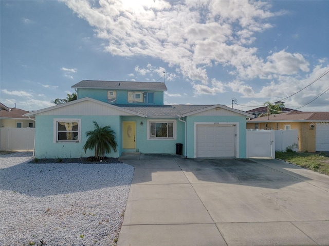 view of front of home featuring driveway, an attached garage, and fence