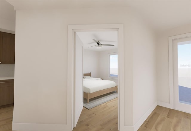 unfurnished bedroom with light wood-style floors, ceiling fan, and baseboards