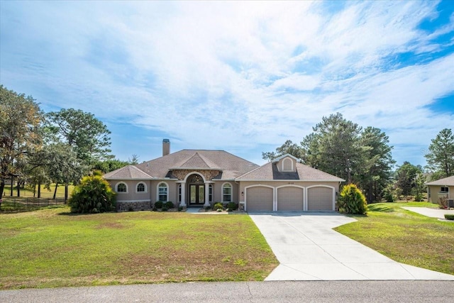 view of front of property featuring a garage, driveway, and a front lawn