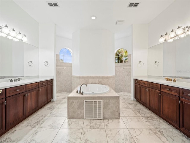 full bathroom featuring two vanities, marble finish floor, and visible vents