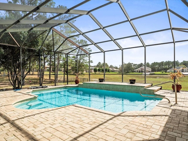 pool featuring glass enclosure, a patio area, and a yard