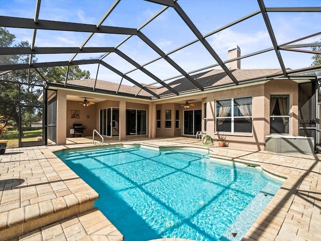 pool featuring a ceiling fan, glass enclosure, and a patio