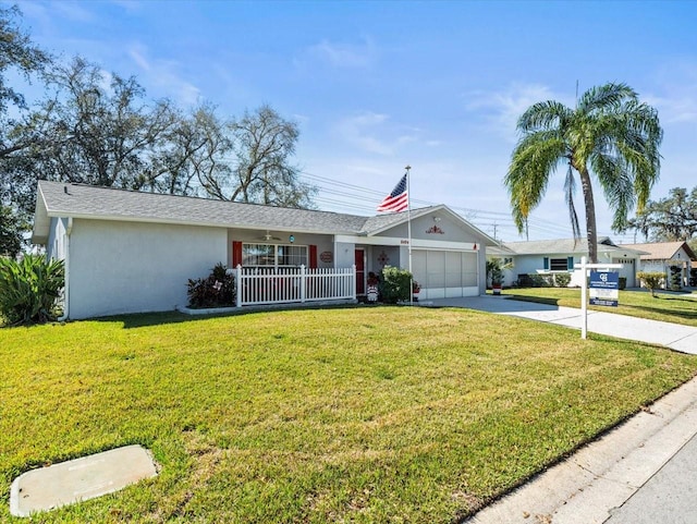 ranch-style home with driveway, a front lawn, an attached garage, and stucco siding