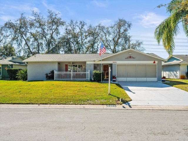 ranch-style house with a garage, a front yard, driveway, and stucco siding