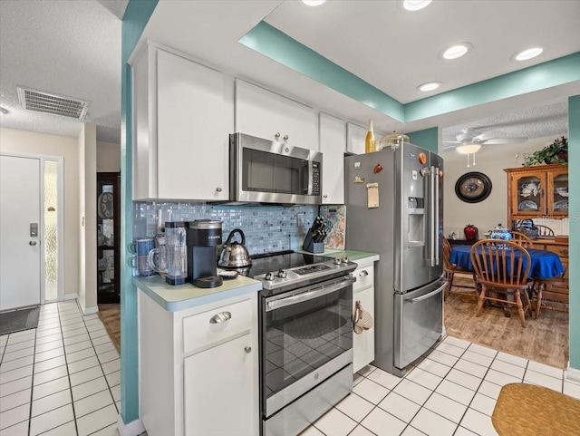 kitchen featuring appliances with stainless steel finishes, white cabinetry, and light countertops