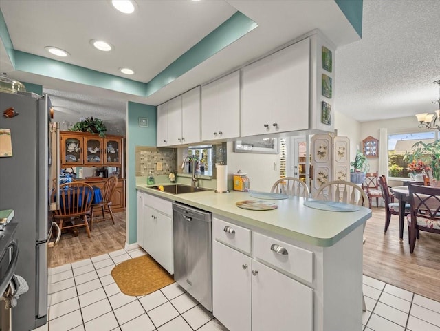 kitchen with white cabinetry, stainless steel appliances, and light countertops