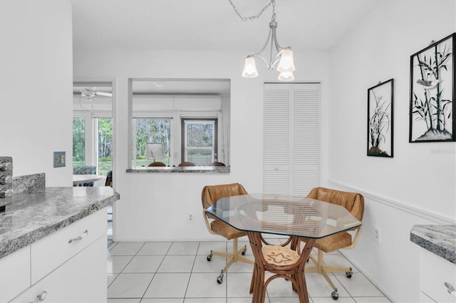 dining area with light tile patterned floors, a wealth of natural light, and a notable chandelier