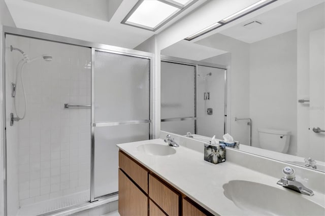 full bath with visible vents, a sink, toilet, and double vanity