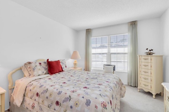 bedroom featuring light colored carpet and a textured ceiling