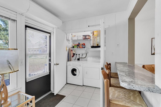 laundry room featuring light tile patterned floors, laundry area, and independent washer and dryer