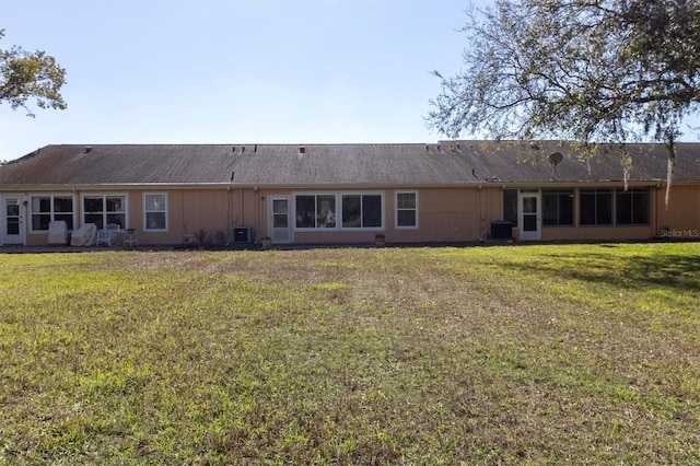 back of property featuring a yard and central AC