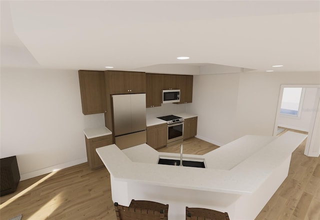 kitchen with light wood finished floors, stainless steel range, baseboards, white microwave, and fridge