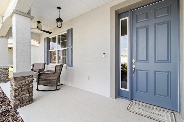 entrance to property with a porch and stucco siding