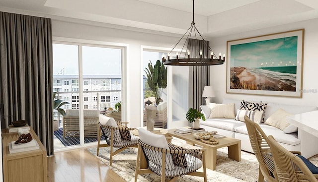 interior space with light wood-type flooring, an inviting chandelier, and a tray ceiling