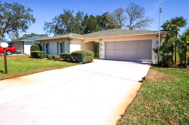 ranch-style house with a garage, concrete driveway, a front yard, and stucco siding