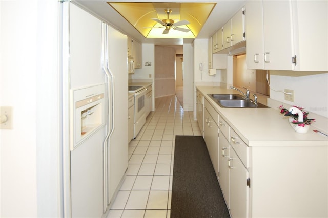 kitchen featuring light tile patterned floors, light countertops, white cabinetry, a sink, and white appliances