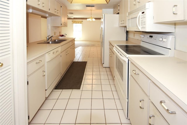 kitchen with light tile patterned floors, white appliances, a sink, light countertops, and hanging light fixtures