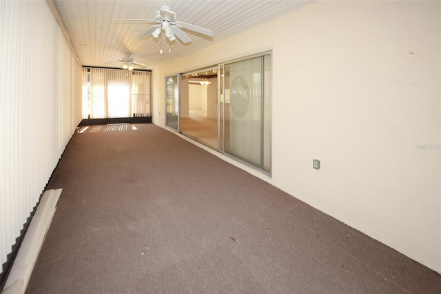 unfurnished room featuring dark colored carpet and a ceiling fan