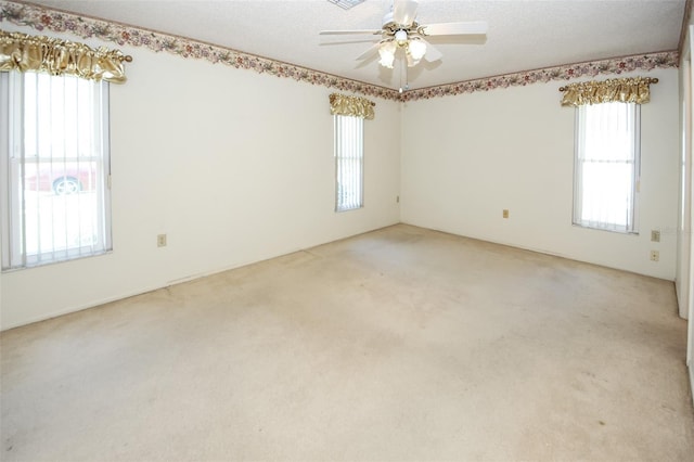 spare room featuring a ceiling fan, a textured ceiling, and light colored carpet