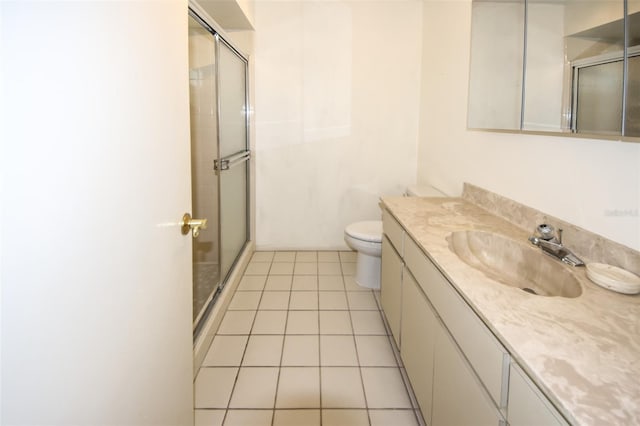 bathroom featuring a stall shower, vanity, toilet, and tile patterned floors