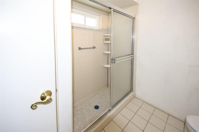 full bath with tile patterned floors, toilet, and an enclosed shower