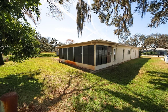 back of property with a sunroom and a yard