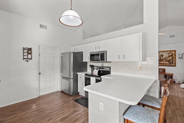 kitchen featuring appliances with stainless steel finishes, decorative light fixtures, a peninsula, light countertops, and white cabinetry