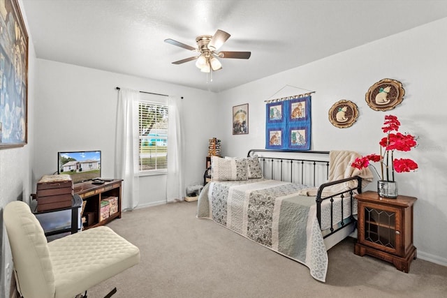 bedroom featuring a ceiling fan, light colored carpet, and baseboards