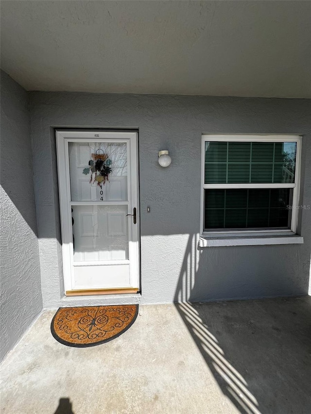 entrance to property with stucco siding