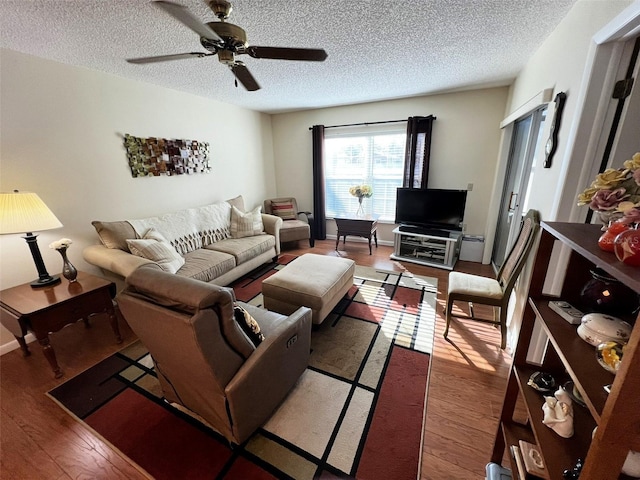 living room featuring a textured ceiling, a ceiling fan, and wood finished floors