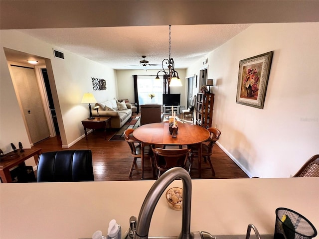 dining area with baseboards, visible vents, ceiling fan, dark wood-style flooring, and a textured ceiling