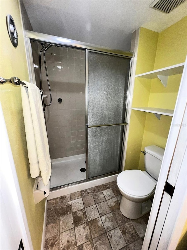 bathroom with visible vents, a shower stall, and toilet