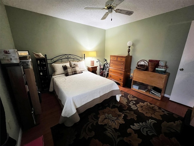 bedroom with a ceiling fan, dark wood finished floors, and a textured ceiling