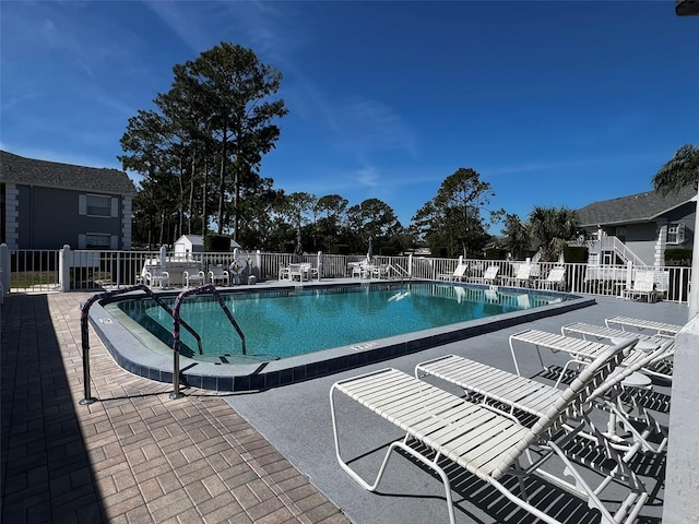 pool featuring fence and a patio