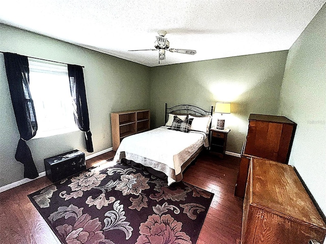 12027 Hoosier Ct Unit 104, Hudson, FL 34667 - bedroom featuring a textured ceiling, dark wood-style floors, baseboards, and ceiling fan