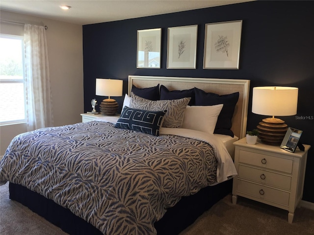 bedroom featuring multiple windows and dark carpet