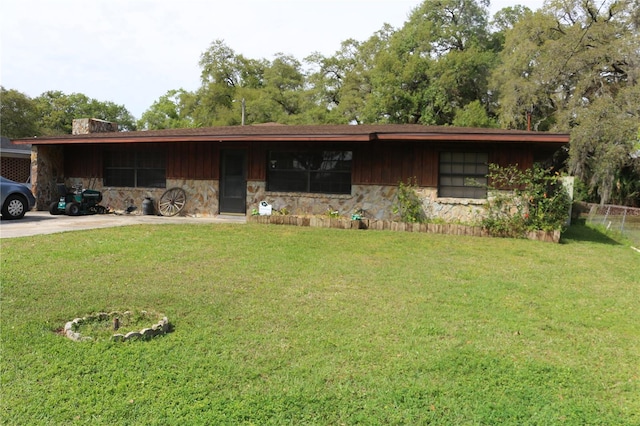 single story home with board and batten siding, stone siding, and a front lawn