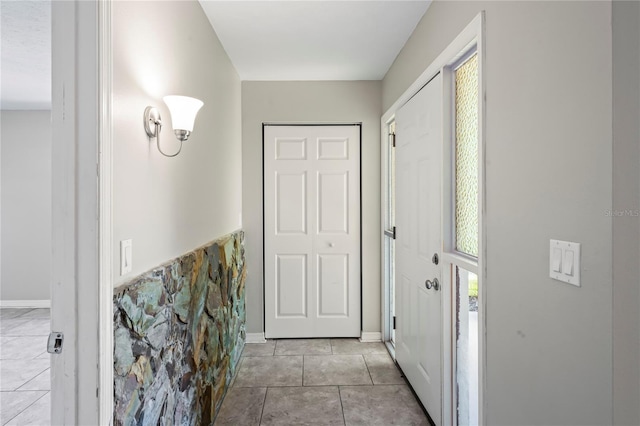 entrance foyer with light tile patterned floors and baseboards