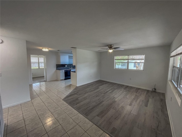 unfurnished living room with a ceiling fan, light tile patterned flooring, and baseboards