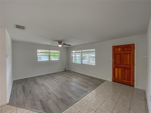 foyer entrance with light wood-type flooring, baseboards, visible vents, and ceiling fan