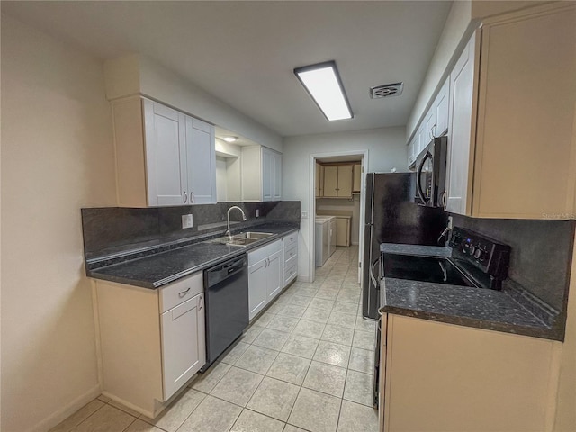 kitchen with a sink, visible vents, white cabinetry, backsplash, and black appliances