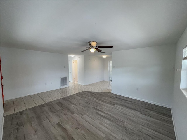 empty room with visible vents, ceiling fan, baseboards, and light tile patterned floors