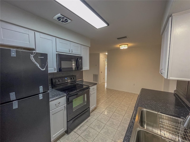 kitchen featuring visible vents, black appliances, dark countertops, and white cabinetry